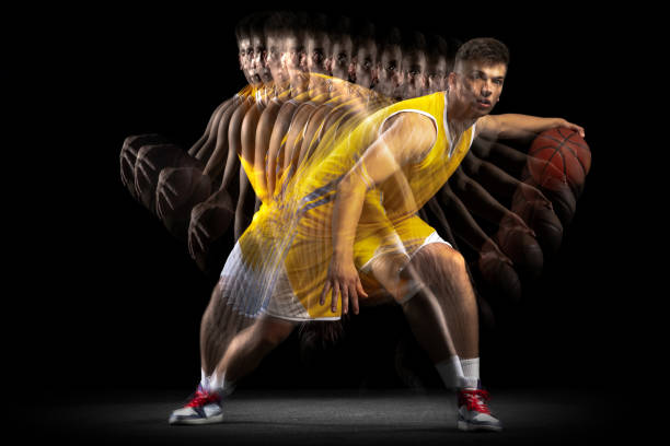 istock Professional basketball player posing with ball isolated on dark background with stroboscope effect. Concept of professional sport, hobby. 1329486718