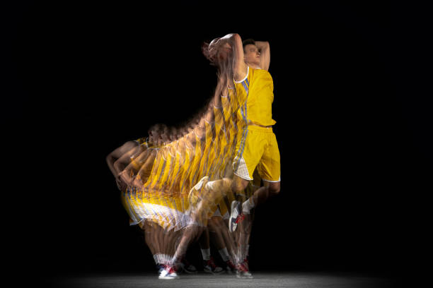 istock One young basketball player training with ball isolated on dark background with stroboscope effect. Concept of professional sport, hobby. 1329486722