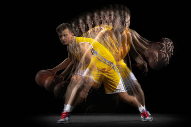 istock Professional basketball player posing with ball isolated on dark background with stroboscope effect. Concept of professional sport, hobby. 1329486724
