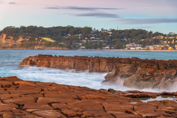 Sunrise seascape with clouds with tessellated rock platform Winter Sunrise Seascape from North Avoca Beach on the Central Coast, NSW, Australia. avoca beach photos stock pictures, royalty-free photos & images