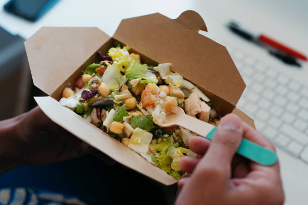 istock man eats a chickpea salad sitting at his desk 1329487062