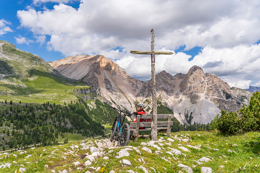 pretty active senior woman riding her electric mountain bike in the Fanes high Valley, part of Fanes-Sennes-Braies nature park in the Alta Badia Dolomites, South Tirol and Trentino, Italy