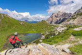woman on electric mountain bike at Passo Valparola, Dolomites Mountains, Italy