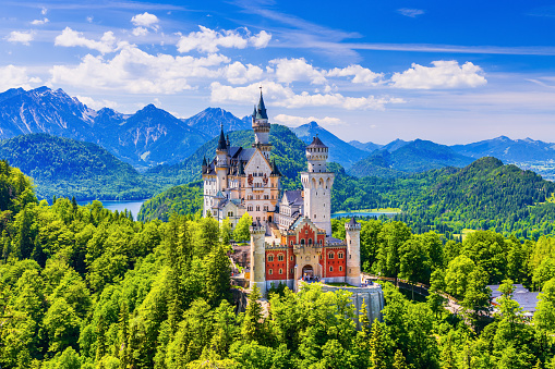 Neuschwanstein Castle, Germany - June 17, 2021: Front view of the castle with the Bavarian Alps in the background.