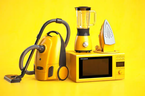 Photo of Yellow household appliances on yellow background. Set of home  technics.