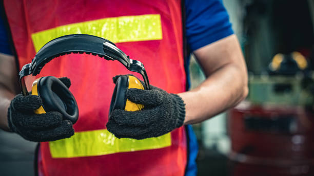 Industrial worker holding ear protection gear equipment. Workplace safety equipment. Blue collar worker concept. ear protectors stock pictures, royalty-free photos & images