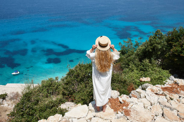istock Woman in hat looking at beautiful blue lagoon 1329494848