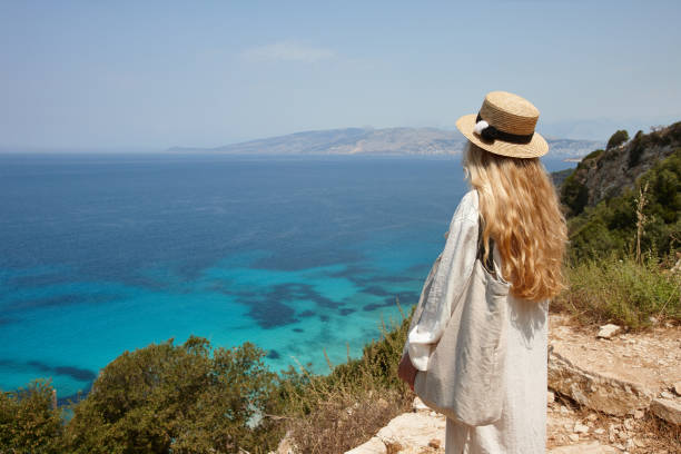 istock Woman in hat looking at beautiful blue lagoon 1329494875