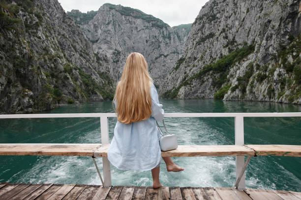 istock Blonde woman enjoying mountain view on a ferry 1329495001