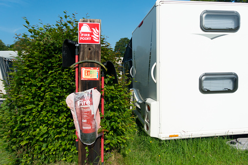 Fire extinguisher  at end of rows of caravans on rural caravan par, keeping everyone safe whilst they Staycation in the UK due to Covid Pandemic.