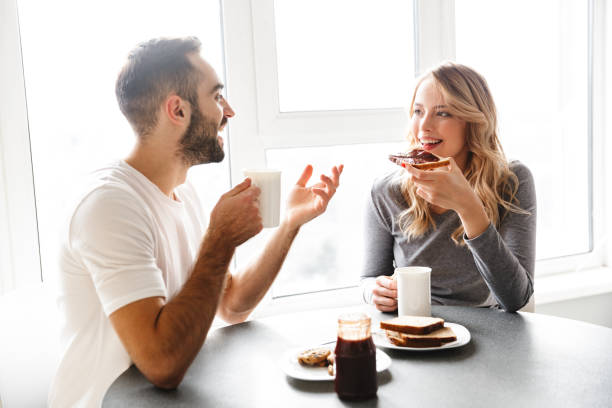istock Young loving couple sitting at the kitchen have a breakfast talking with each other. 1329495949