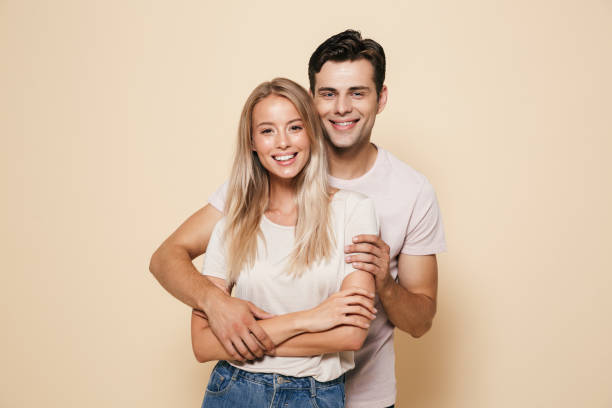 Portrait d’un jeune couple souriant debout ensemble - Photo