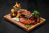 Grilled assorted meat platter with potato wedges and sauces