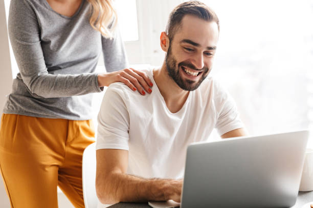 istock Amazing happy young loving couple sitting at the kitchen using laptop computer. 1329497048