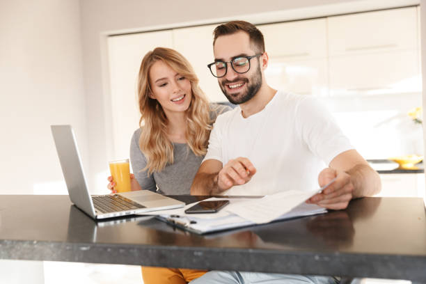 istock Amazing happy young loving couple sitting at the kitchen using laptop computer. 1329497108