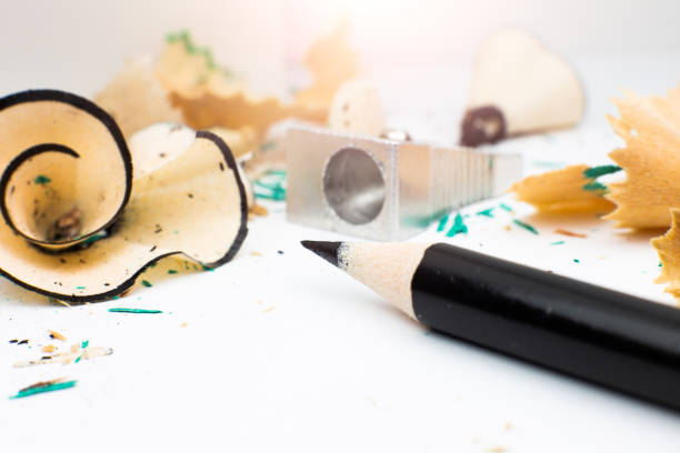 Sharpener and a broken pencil. Shavings and a graphite on white background. Close up, Macro photo. Back to school concept.