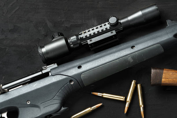 istock The optical sight and shotgun on wooden backgorund 1329498339