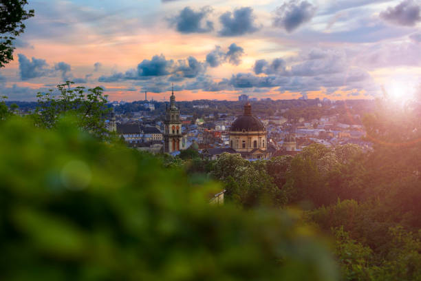 European city Lviv Ukraine landmark scenery from top view point historical center cathedral dome and town hall tower in colorful bright evening sun light and glare time wallpaper pocter picture ciudad europea lviv ucrania paisaje emblemático desde el punto de vista superior centro histórico cúpula de la catedral y la torre del ayuntamiento en colorido brillante luz del sol de la tarde y el tiempo de deslumbramiento concepto pocter fondo de pan