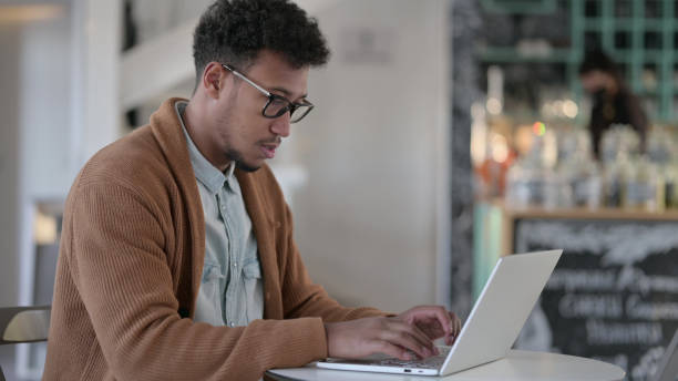 istock African Man Working on Laptop in Cafe 1329500905