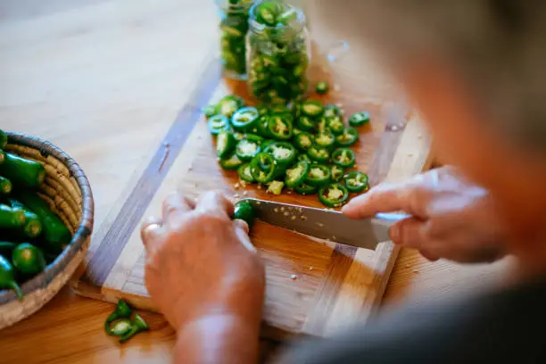 Woman Preparing Pickles With Jalapeno Peppers