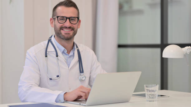 istock Middle Aged Doctor in Hospital Smiling at the Camera 1329501183