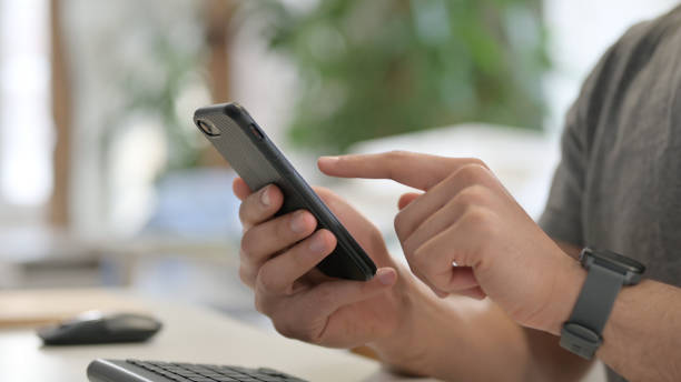 istock Hands of Young Man Using Smartphone, Close Up 1329501231
