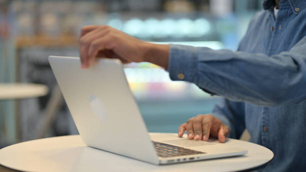 istock African Man Opening Laptop and Typing in Cafe, Close Up 1329501913