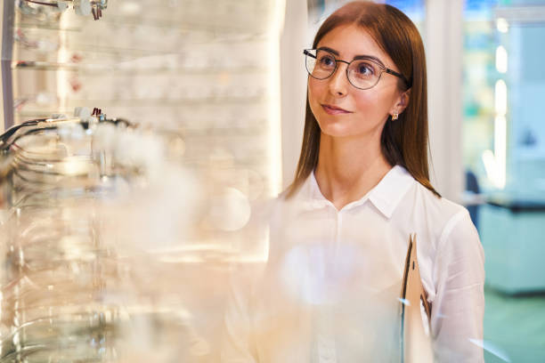 istock Charming young woman optician working in optical store 1329502019