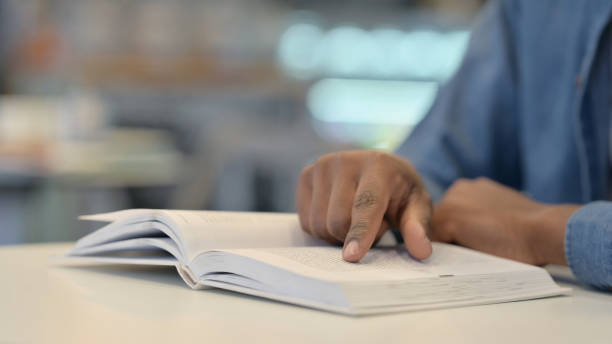 istock Close Up of African Man Reading Book 1329502078