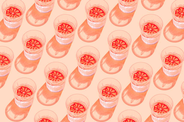 Creative pattern made with glass with lemonade or water and sliced citrus on pastel background. Summer fruit and refreshment  concept. Minimal style. Sunlit flat lay. Top view Creative pattern made with glass with lemonade or water and sliced citrus on pastel background. Summer fruit and refreshment  concept. Minimal style. Sunlit flat lay. Top view grapefruit photos stock pictures, royalty-free photos & images