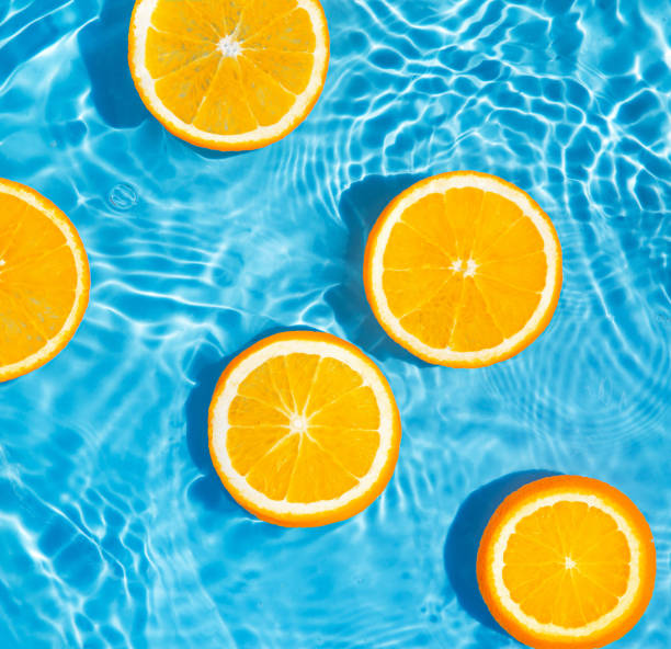 istock Creative summer composition made of sliced orange in transparent pool water. Refreshment concept. Healthy refreshing drink theme. Top view 1329503377