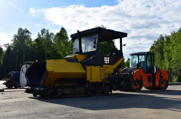 istock Asphalt paver machine during road work. Road roller at construction site for paving works. 1329503388