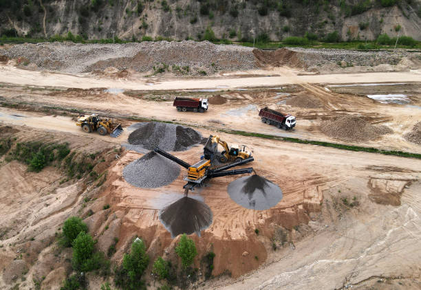 istock Arial view of the open pit mine. Front end loader loading gravel into stone jaw crusher in open-pit. 1329503405