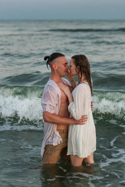 istock happy beautiful couple walking at sunset along the seashore 1329503671