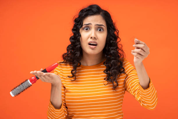 young woman with hair loss holding comb hair fall concept - indian falls imagens e fotografias de stock