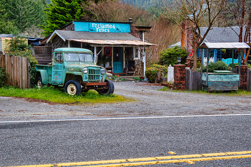 Garberville, United States - February 15 2020: an old rustic and classic pick up truck along the road is used as advertisement billboard for a small store