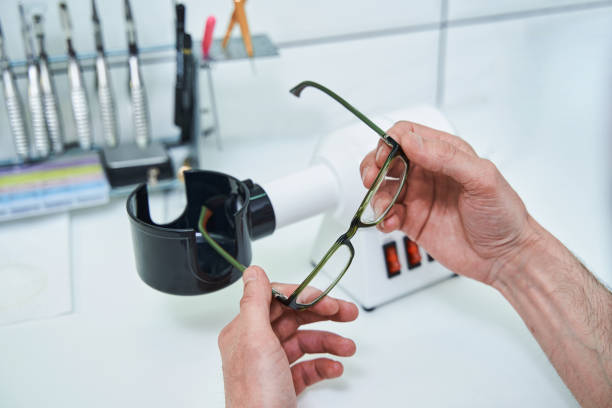 istock Male optician hands holding glasses with green frame 1329505007