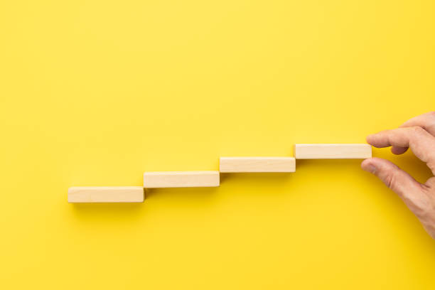 istock stairs made by wooden bricks over yellow background. above view. abstract creative staircase. business strategy concept. achievement conceptual 1329506068
