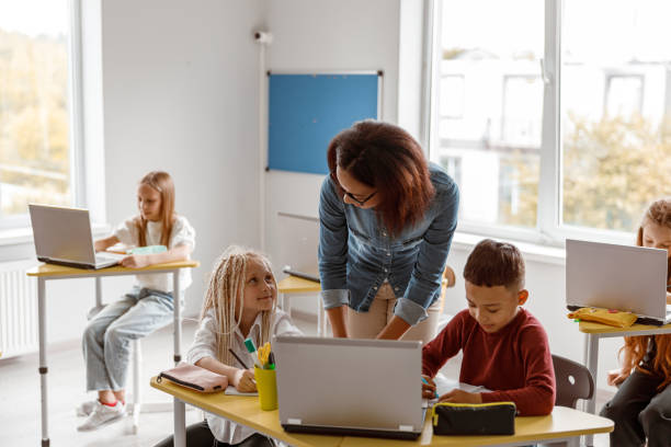 istock Female teacher explaining the task to schoolchildren 1329507662