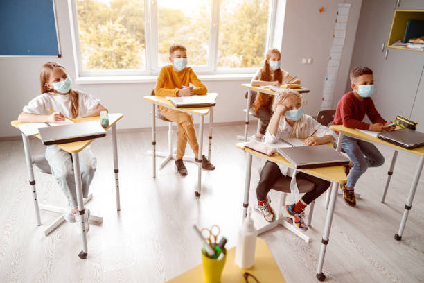istock School kids with notebooks sitting in classroom together 1329507667