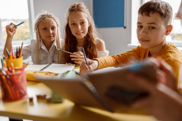 istock Kids studying at school and sitting at the table 1329507685