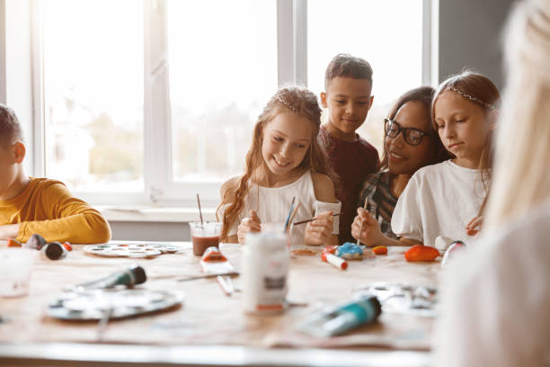 istock Smiling classmates making art painting using water colors 1329507761