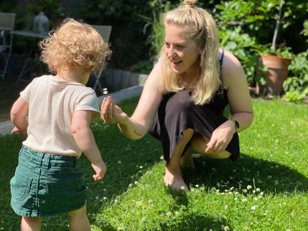 istock Mother picking daisy with her baby daughter 1329509027