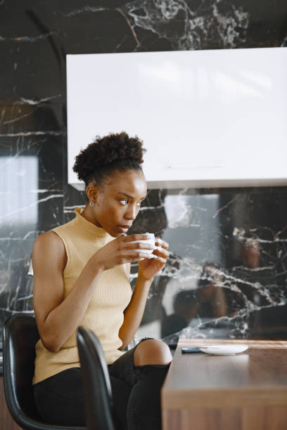 istock African girl drinks coffee in kitchen by windows 1329510448
