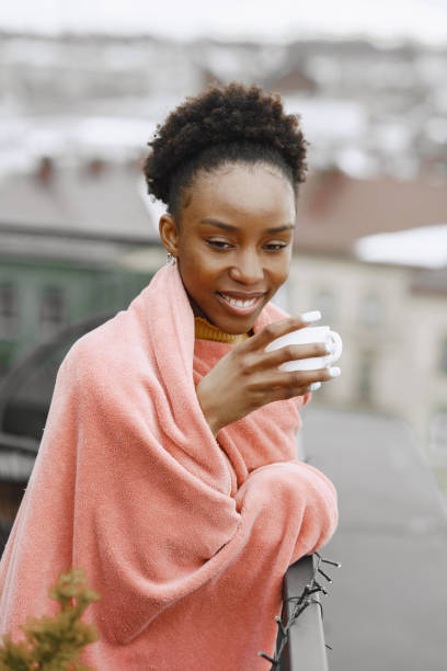 istock Girl in a plaid on balcony drinks coffee 1329510491