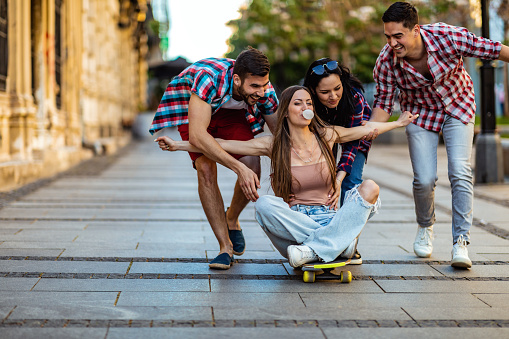 Young Group of Students is Riding on a Skateboard in a City Streets.
