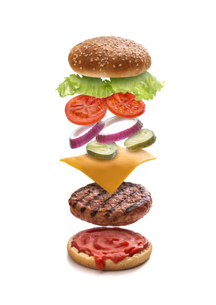 istock Burger layered ingredients as explosion flying open bun isolated on white 1329513080