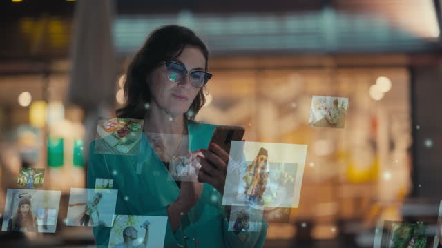 Senior Caucasian brunette woman using a smartphone on the street in the evening. Communication network. Hologram floating photos