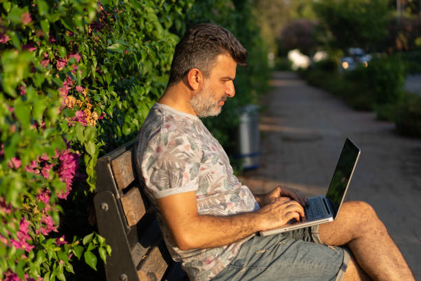 istock Entrepreneur working on his laptop in public park 1329514486