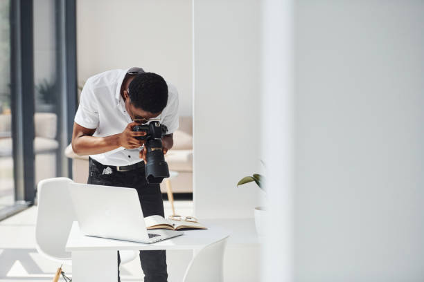istock Testing camera. Young african american man in formal clothes is in the office 1329514708